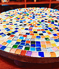 Handcrafted round rainbow mosaic plant stand with colorful tile design, perfect for showcasing potted plants in home decor.