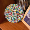 Handcrafted mosaic plant stand with blue and amber tiles, designed to hold potted plants in a stylish indoor or outdoor setting.