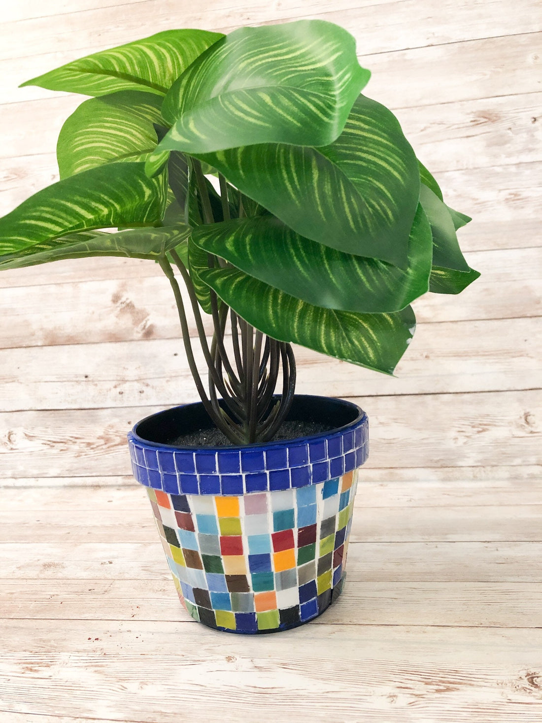 Colorful artisan rainbow mosaic planter with intricate tile design, perfect for outdoor or indoor plants.