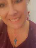 Turquoise glass cross set in silver jewelry, featuring multiple cross pendants with detailed silver accents and chain links.