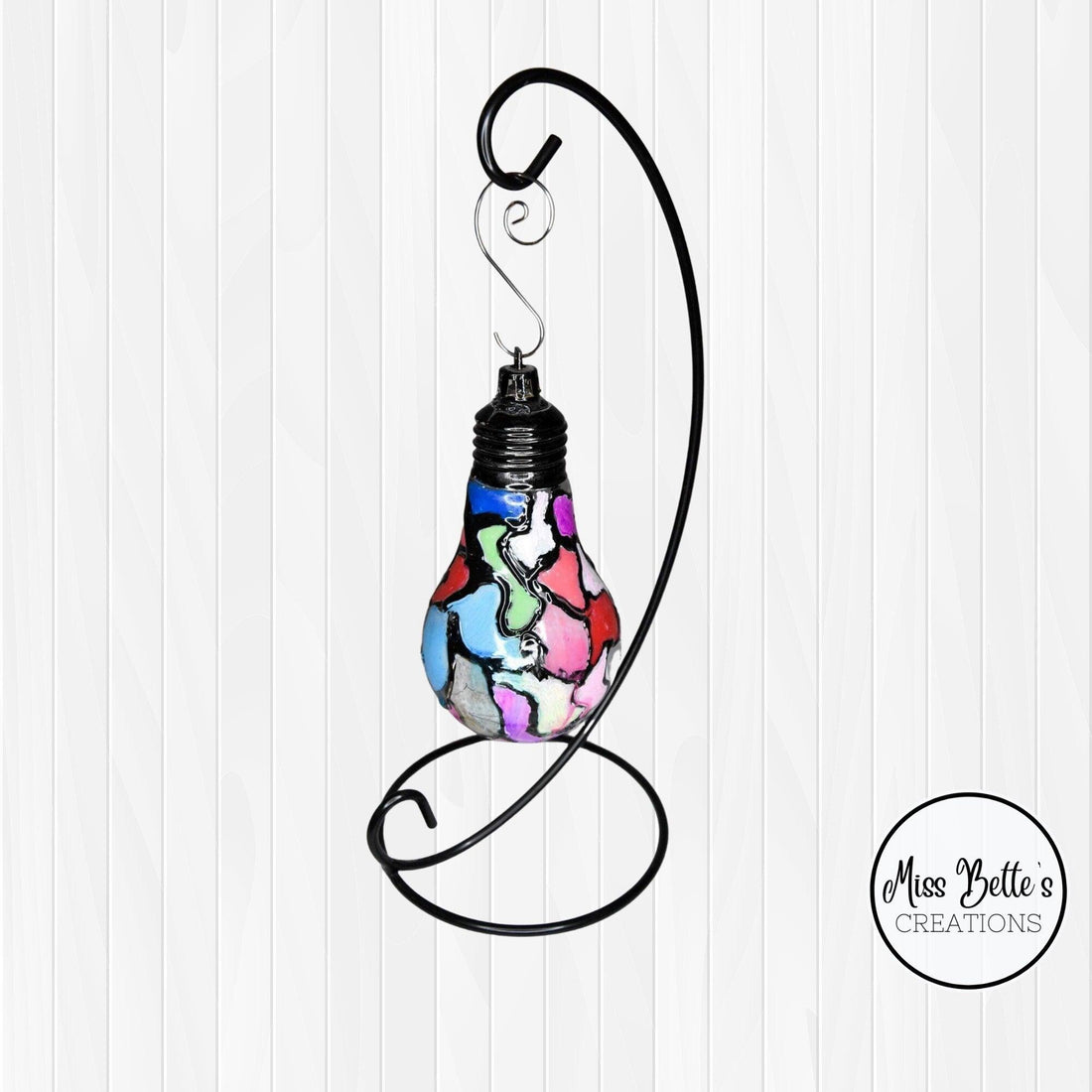 Handmade stained glass light bulb with mosaic design, holiday ornament featuring colorful, intricate glass patterns.