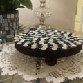 Handmade black and white iridescent mosaic plant stand with geometric design and sturdy base.