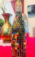 Stained glass look wine decanter with intricate colorful design, elegant shape, and glass stopper for pouring and serving wine.