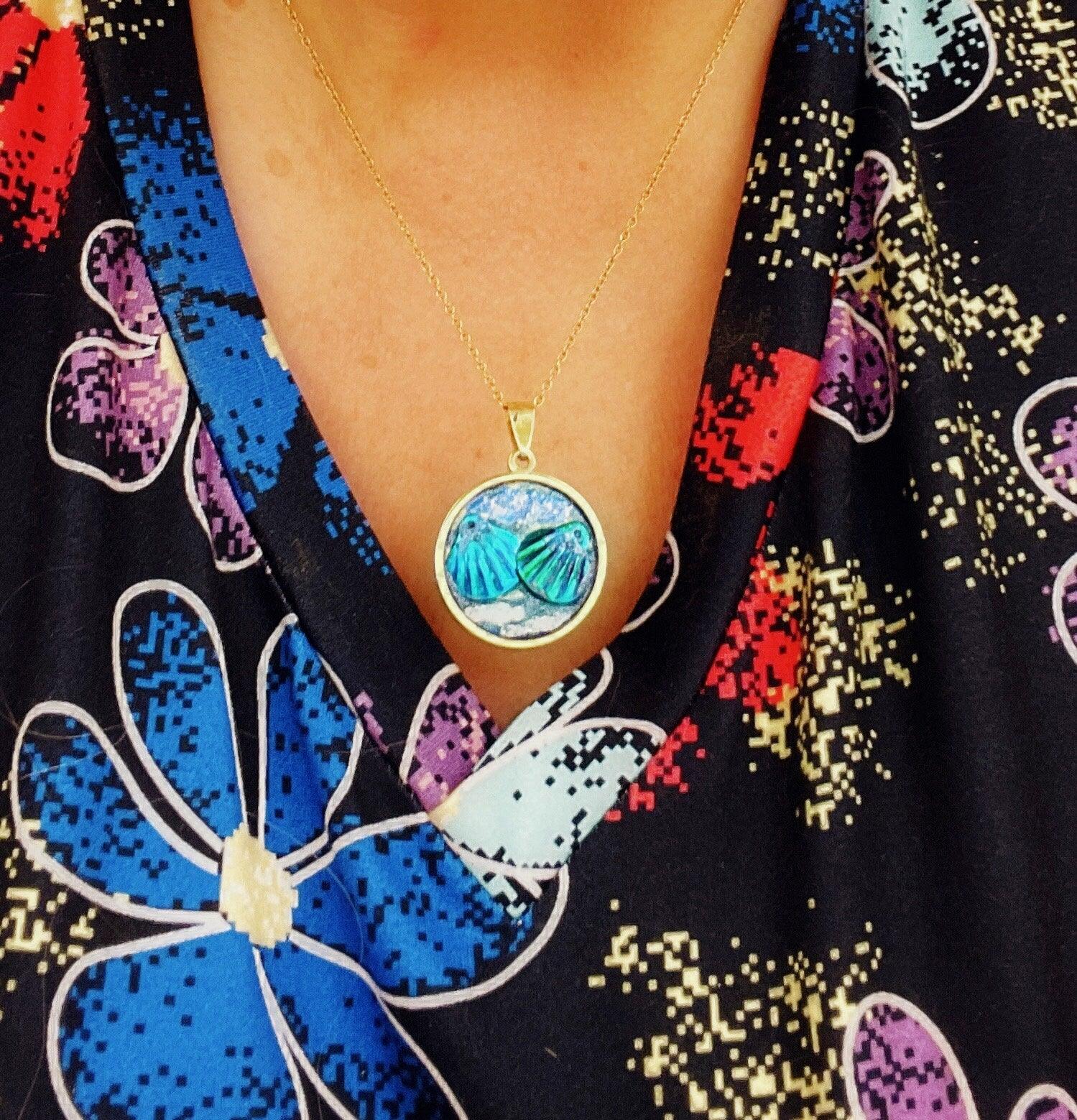 Ocean blue shell medallion necklace featuring a round shell pendant on a delicate chain, stylish jewelry accessory.