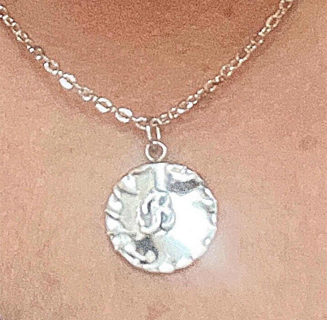 Vintage initial charm necklace with a gold chain and engraved initial pendant, stylish accessory for everyday wear.