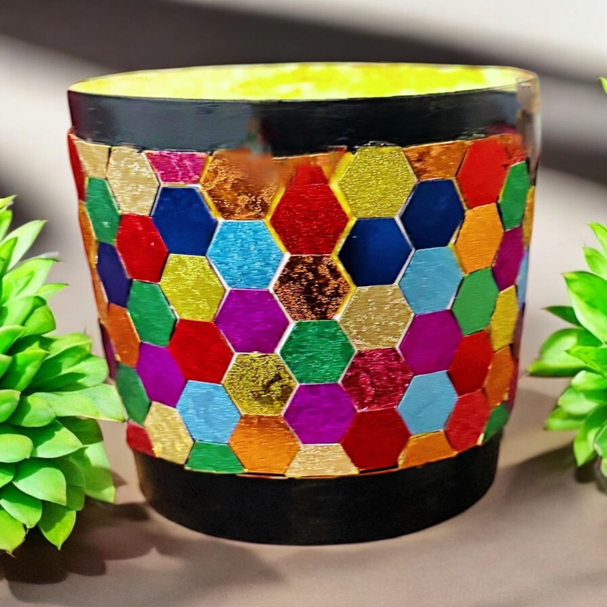 Colorful flower bouquet in a rainbow mosaic hexagon planter with green foliage, vibrant and decorative for home or garden.
