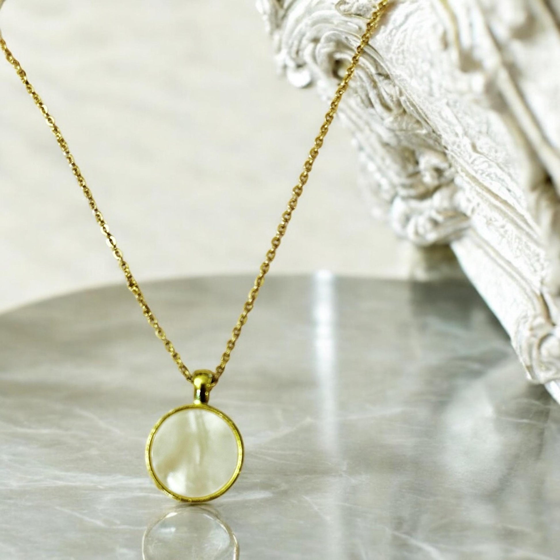 Iridescent shell resin circle pendant showcasing shimmering, colorful surface with a smooth, polished finish.