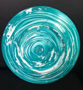 Iridescent turquoise mosaic glass wall art featuring vibrant, reflective tiles arranged in an abstract design.