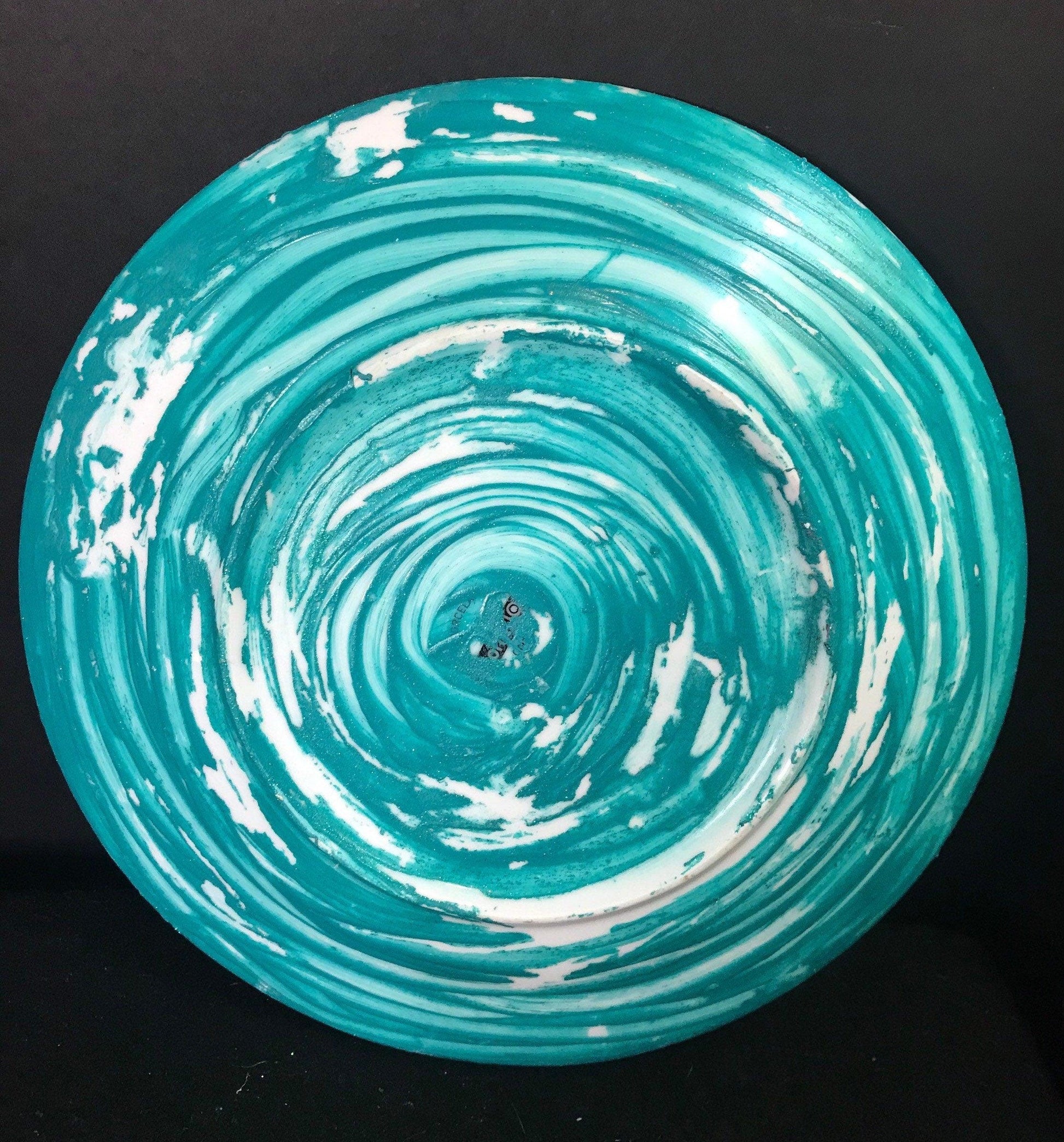 Iridescent turquoise mosaic glass wall art featuring vibrant, reflective tiles arranged in an abstract design.