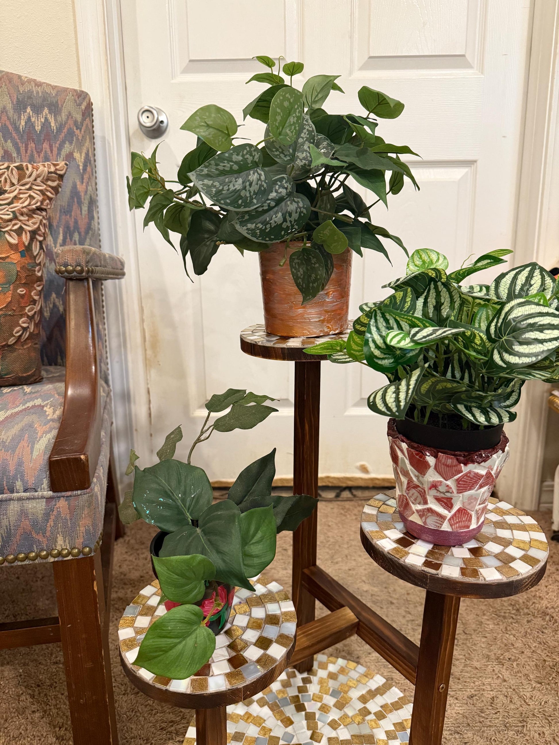 Handcrafted 3-tier mosaic plant stand with colorful tiles, designed to hold multiple potted plants, showcasing intricate craftsmanship.