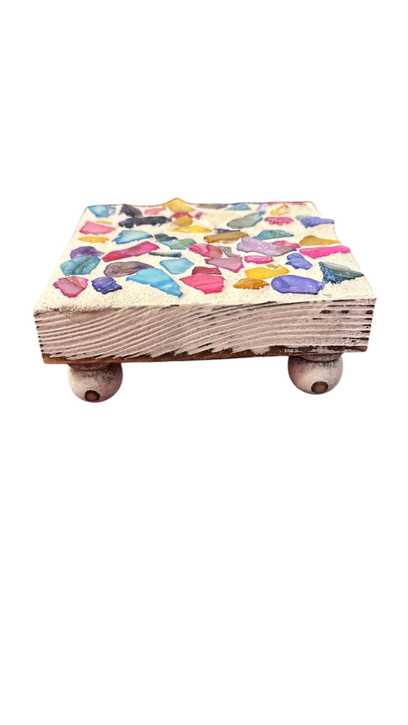 Square multicolored shell plant stand with open design and vibrant shell accents, perfect for displaying potted plants.