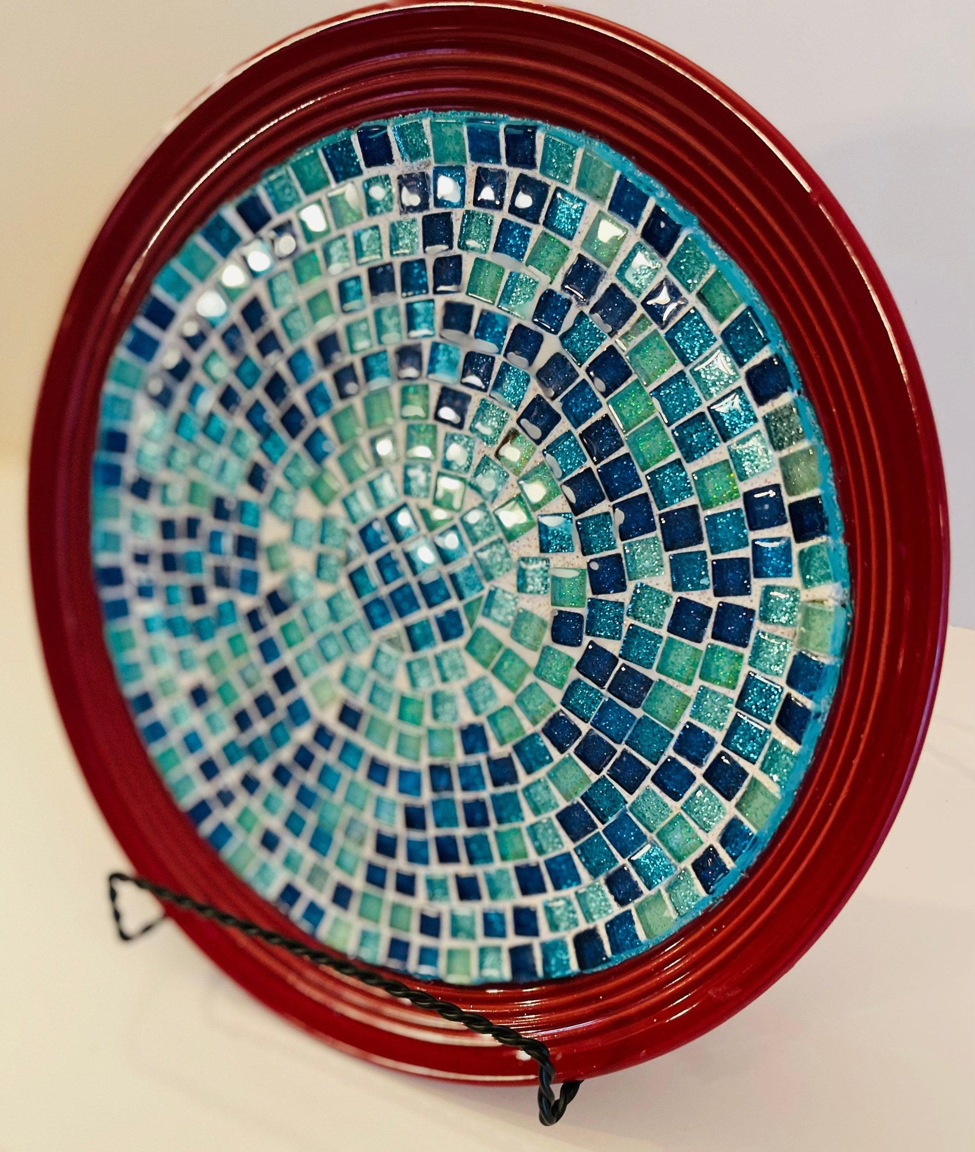Deep crimson ceramic plate featuring an Ocean Breeze mosaic pattern with vibrant blue and white ocean-inspired designs.
