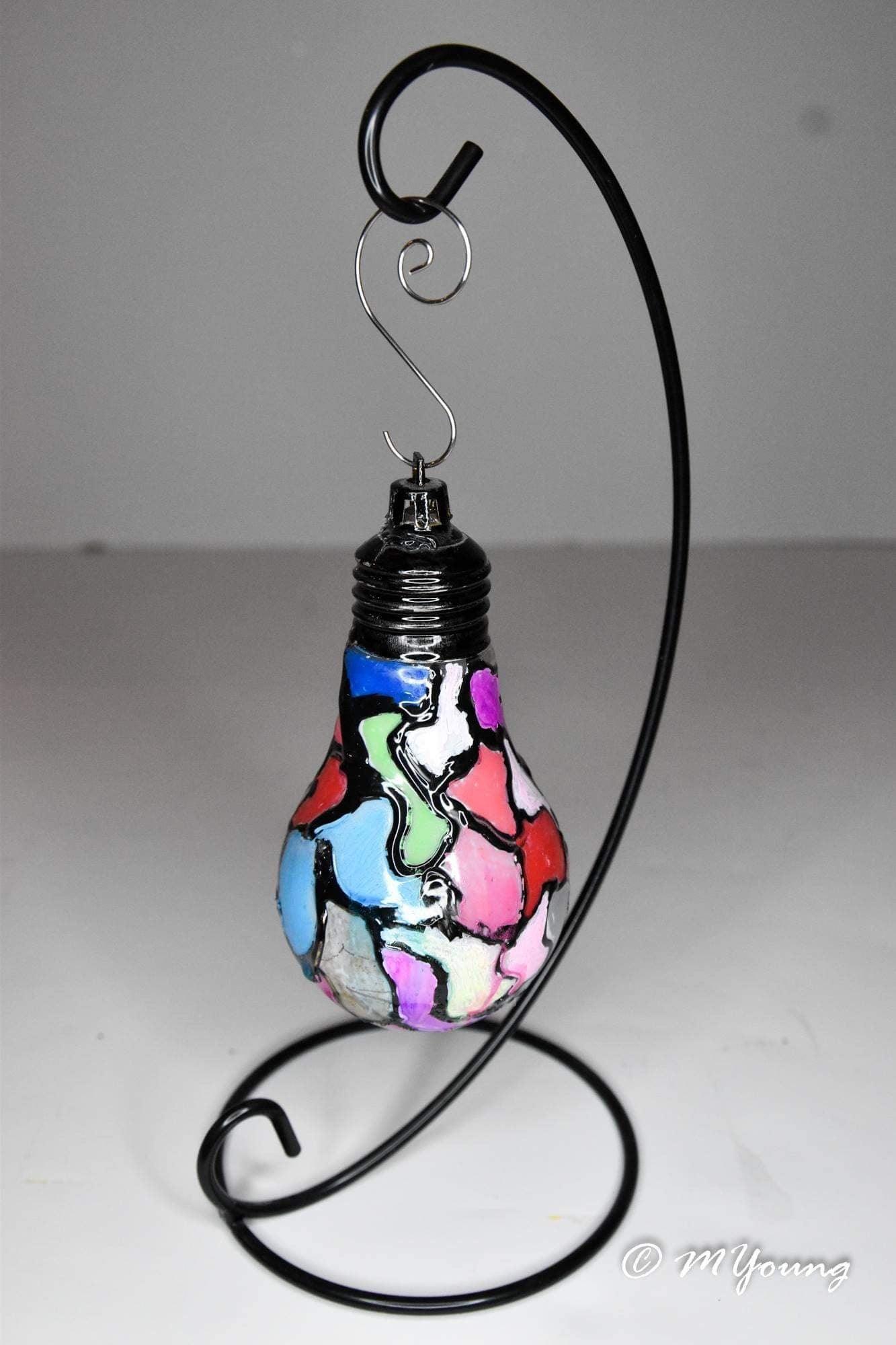 Handmade stained glass light bulb mosaic ornament with colorful holiday design, showcasing intricate glass pieces and vibrant colors.