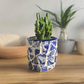 White broken china mosaic planter with intricate mosaic pattern, perfect for adding decorative greenery to indoor or outdoor spaces.