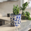 White broken china mosaic planter with intricate mosaic design, perfect for indoor or outdoor plant display.