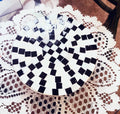 Handmade black and white checkered mosaic plant stand with sturdy design, perfect for displaying potted plants indoors.