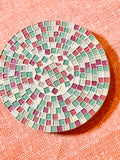 Handcrafted pink and green mosaic plant stand by Miss Bette's Creations, showcasing colorful tile design and sturdy wooden structure.