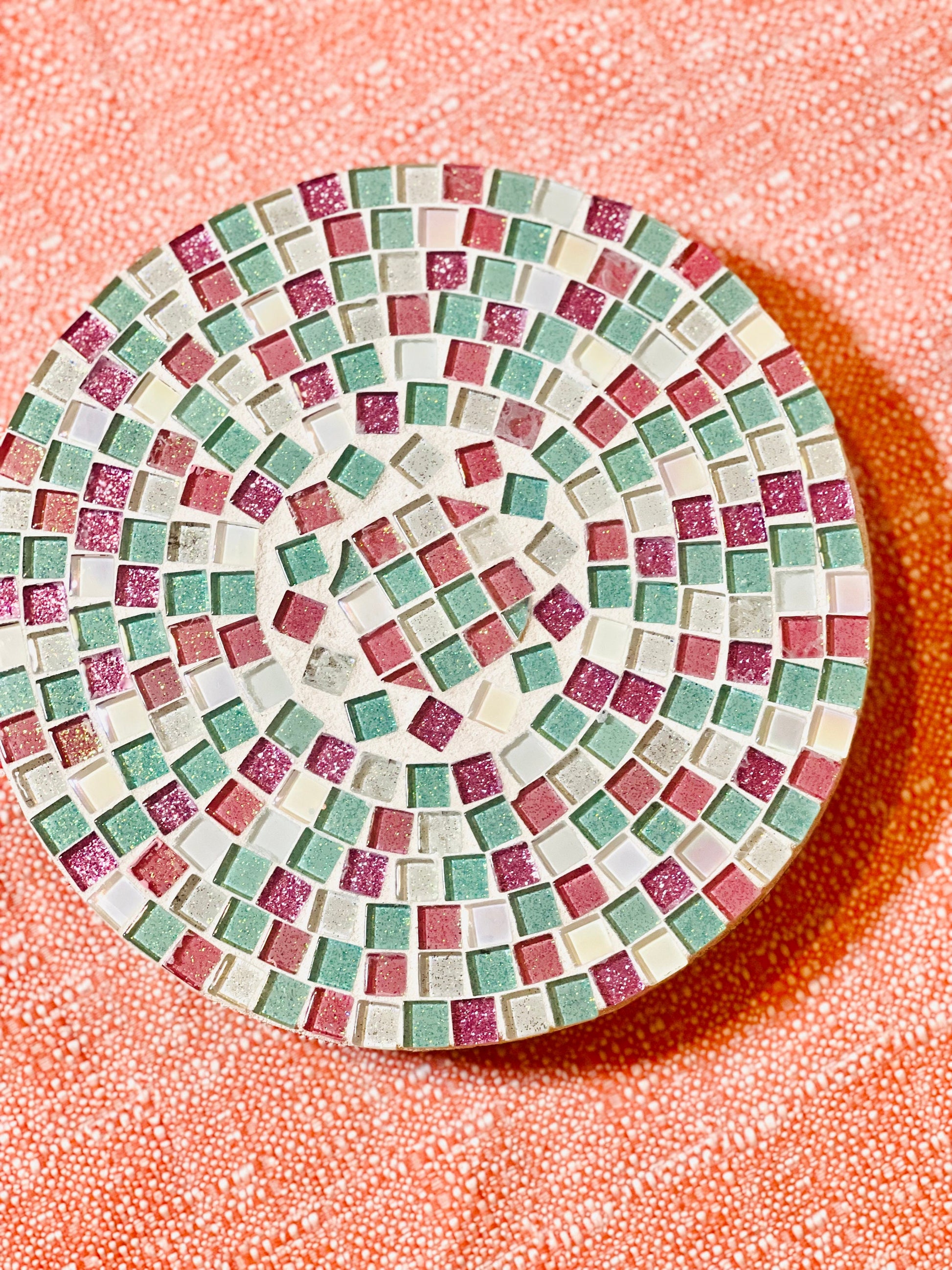 Handcrafted pink and green mosaic plant stand by Miss Bette's Creations, showcasing colorful tile design and sturdy wooden structure.
