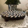 Handmade black and white iridescent mosaic plant stand with a round top and decorative base, perfect for indoor plants.