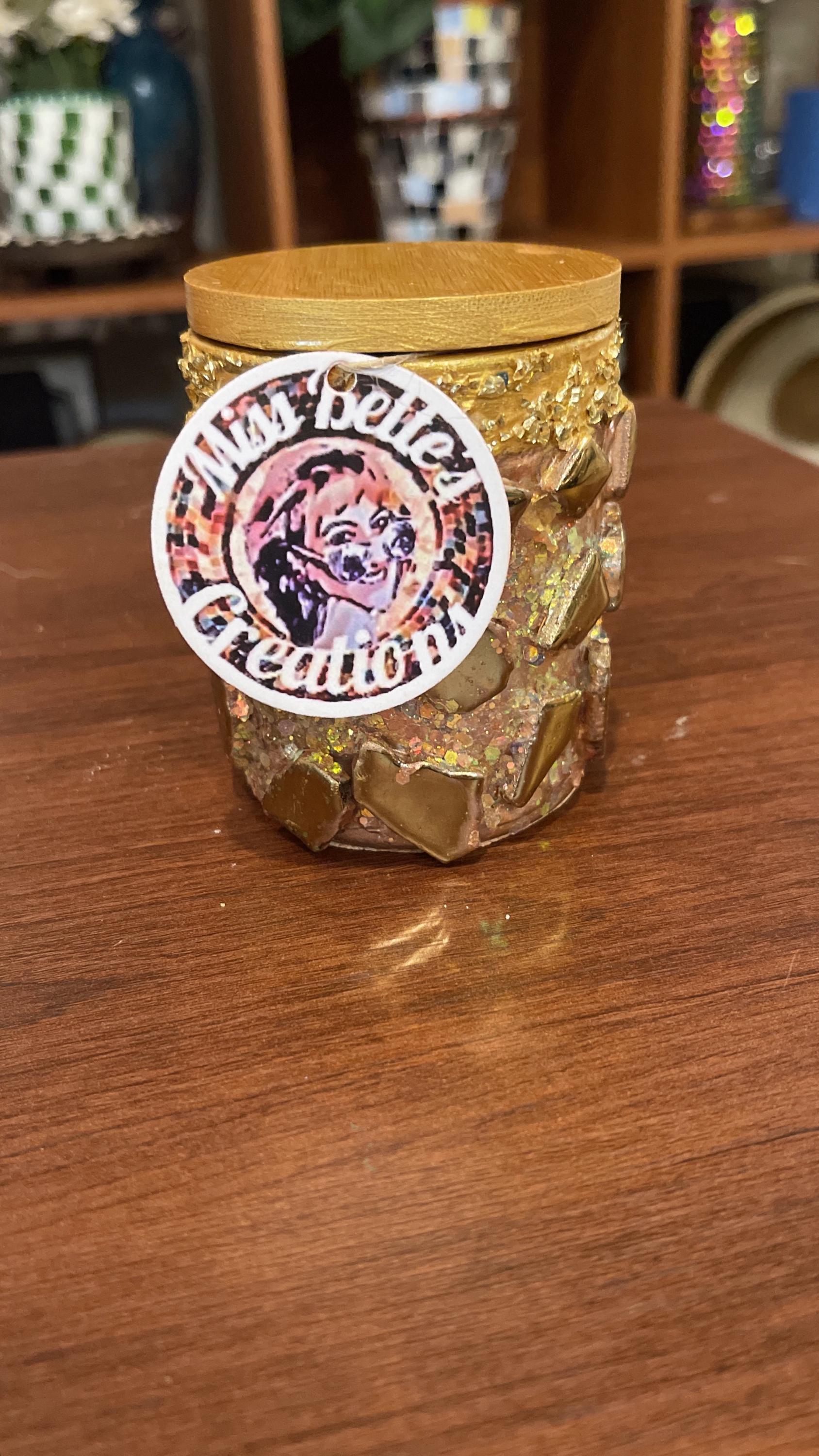 Handmade eucalyptus scented candle in a gold mosaic glass jar, showcasing intricate craftsmanship and elegant design.