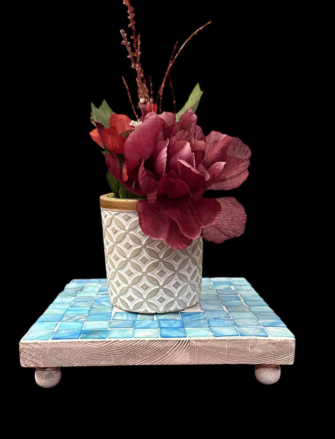 Handcrafted square turquoise plant stand with four legs, made of wood, designed to elevate potted plants with a vibrant finish.