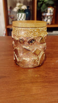 Handmade eucalyptus scented candle in a gold mosaic glass jar, showcasing intricate craftsmanship and warm candlelight.