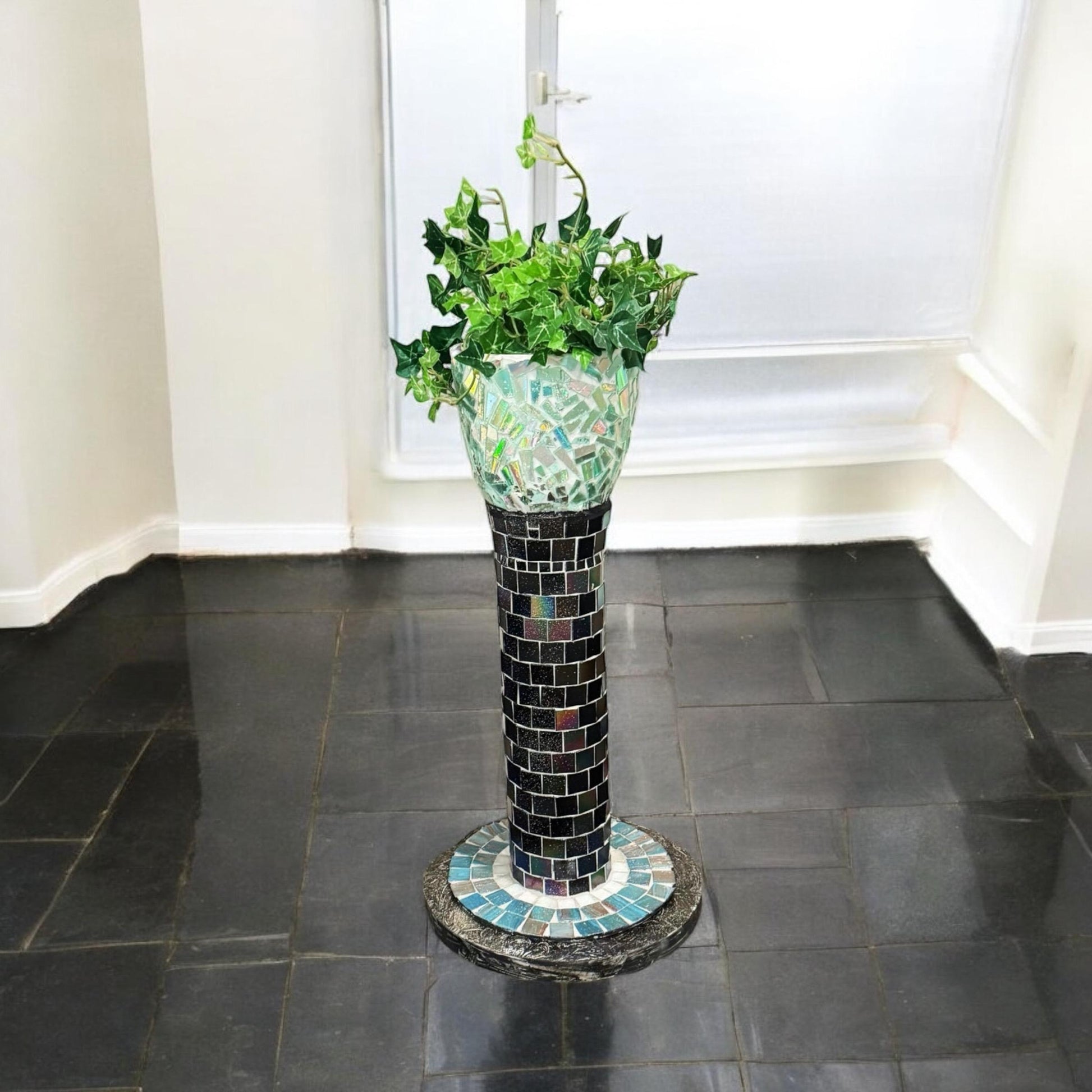 Handcrafted mosaic pedestal planter with colorful tiled design, ideal for displaying indoor or outdoor plants.
