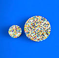 Handcrafted round rainbow mosaic plant stand with colorful tiled design, perfect for displaying indoor or outdoor plants.