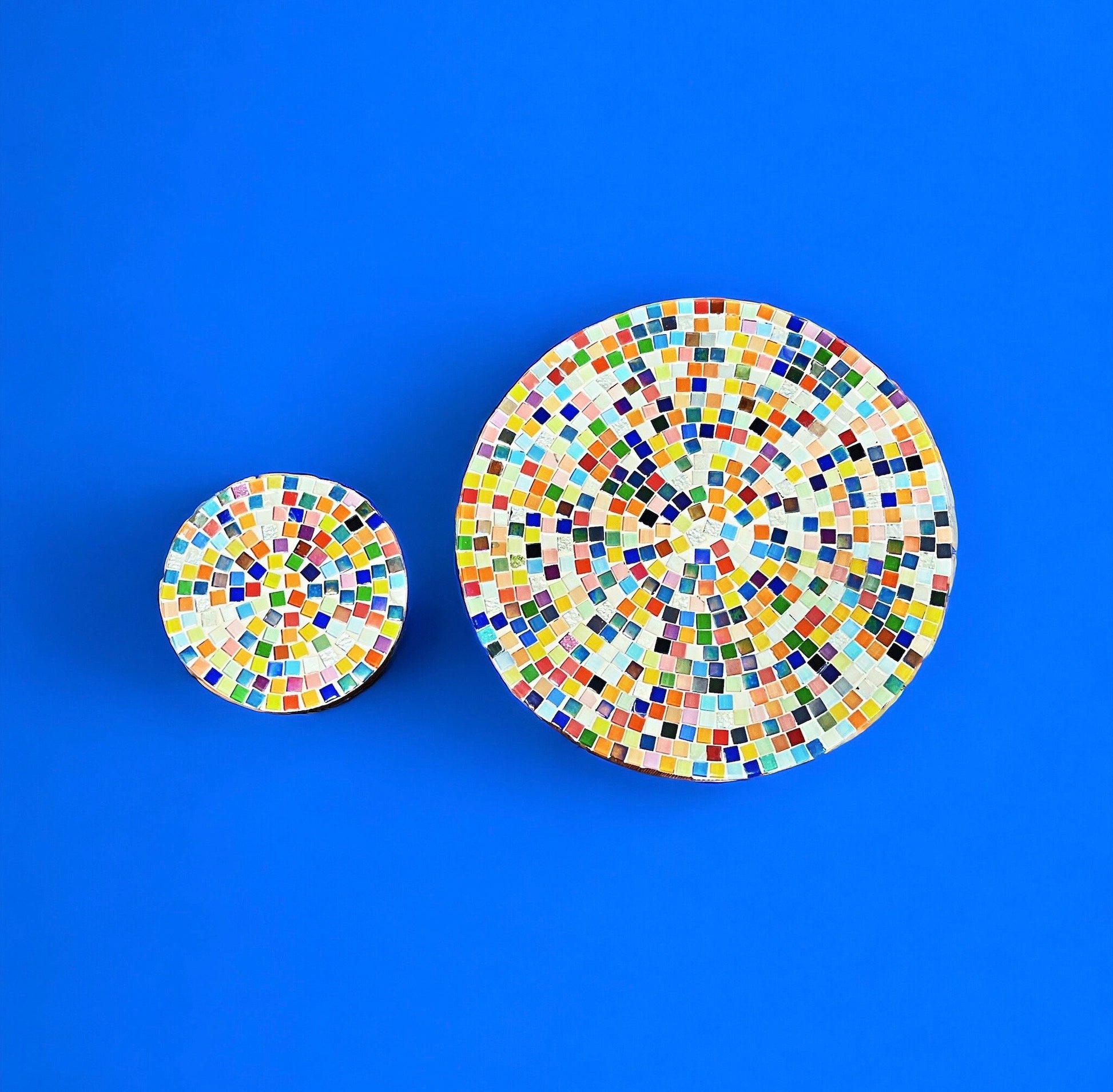 Handcrafted round rainbow mosaic plant stand with colorful tiled design, perfect for displaying indoor or outdoor plants.