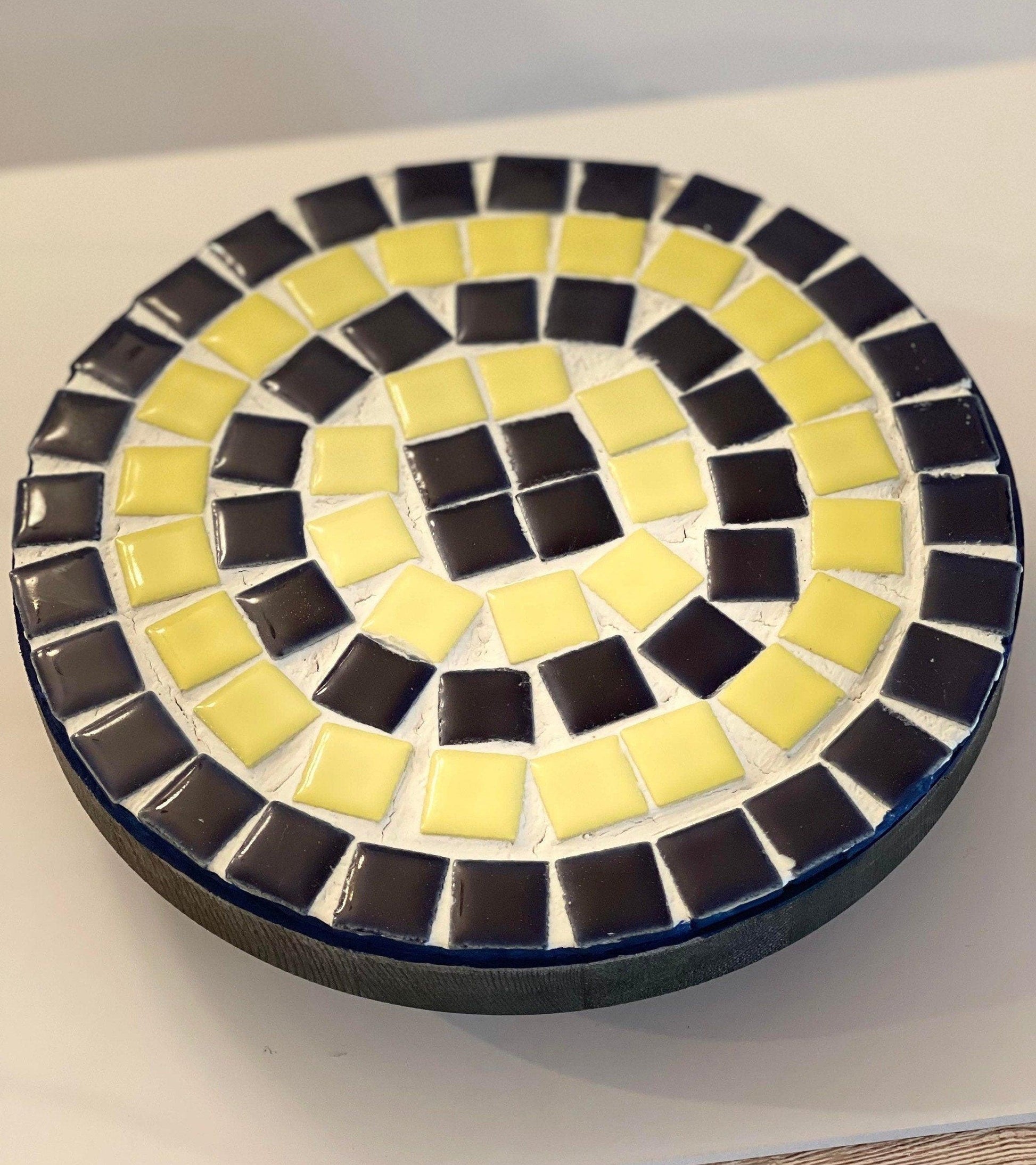 Handmade cobalt blue and yellow mosaic plant stand with intricate tile design, perfect for showcasing potted plants.