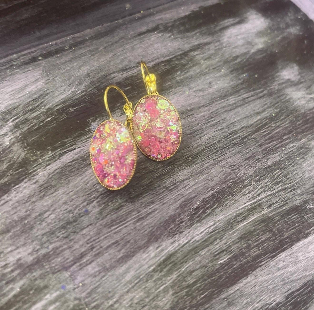 Pink iridescent glass crystal earrings with stainless steel gold posts, showcasing shimmering facets and elegant design.
