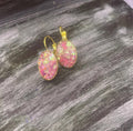 Pink iridescent glass crystal earrings with stainless steel gold posts, showcasing a sparkling and elegant jewelry design