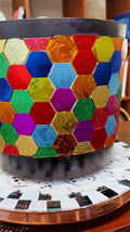 Colorful bouquet of flowers in a rainbow mosaic hexagon planter, showcasing vibrant blooms and decorative ceramic design.