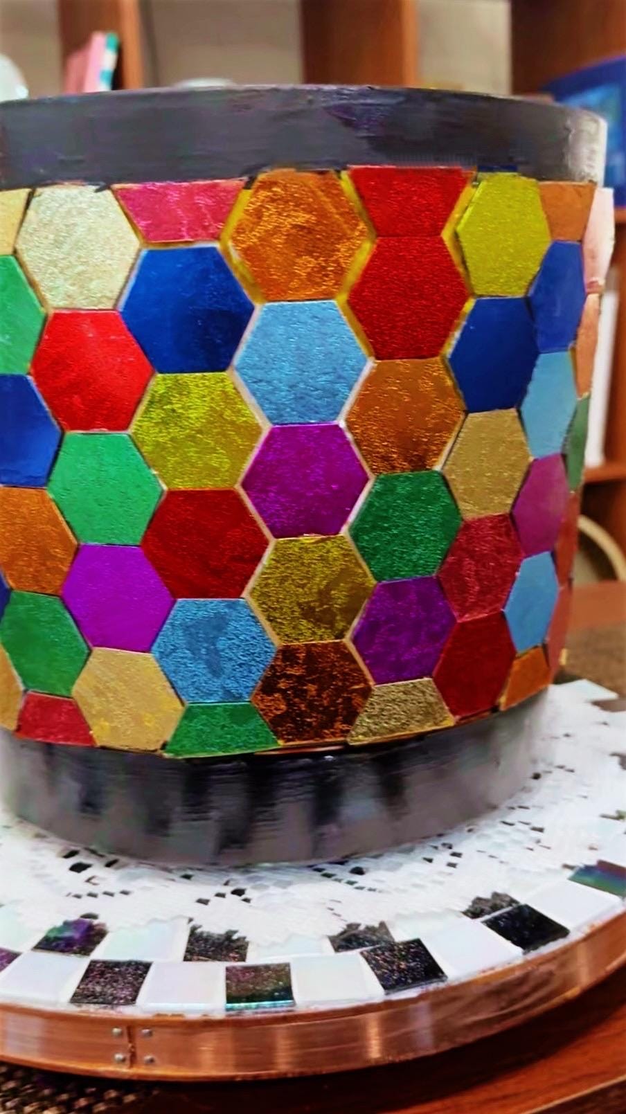 Colorful bouquet of flowers in a rainbow mosaic hexagon planter, showcasing vibrant blooms and decorative ceramic design.