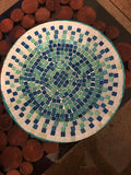 Iridescent turquoise mosaic glass wall art with shimmering geometric patterns, perfect for modern interior decor.