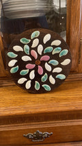 Handcrafted petal mosaic wooden plant stand with colorful petal design, ideal for displaying potted plants in a stylish indoor or outdoor space.