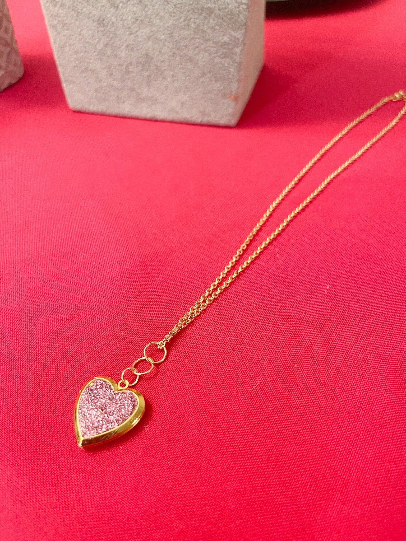 Gold sparkling rose-shaped heart locket with intricate detailing, perfect for jewelry lovers.